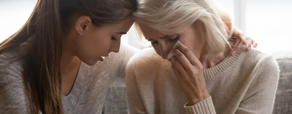 mom talking to adult daughter while she is comforting her