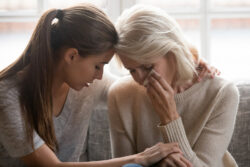 mom talking to adult daughter while she is comforting her